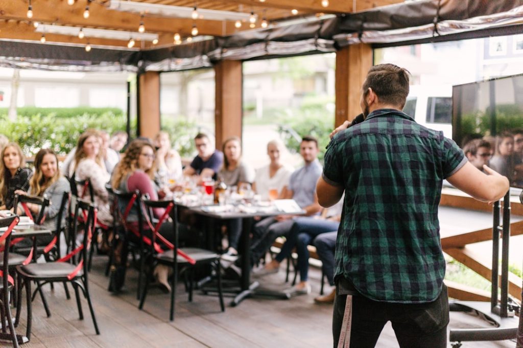 man-standing-infront-of-group-of-people-q7wgvnbuwj0 man-standing-infront-of-group-of-people-q7wgvnbuwj0